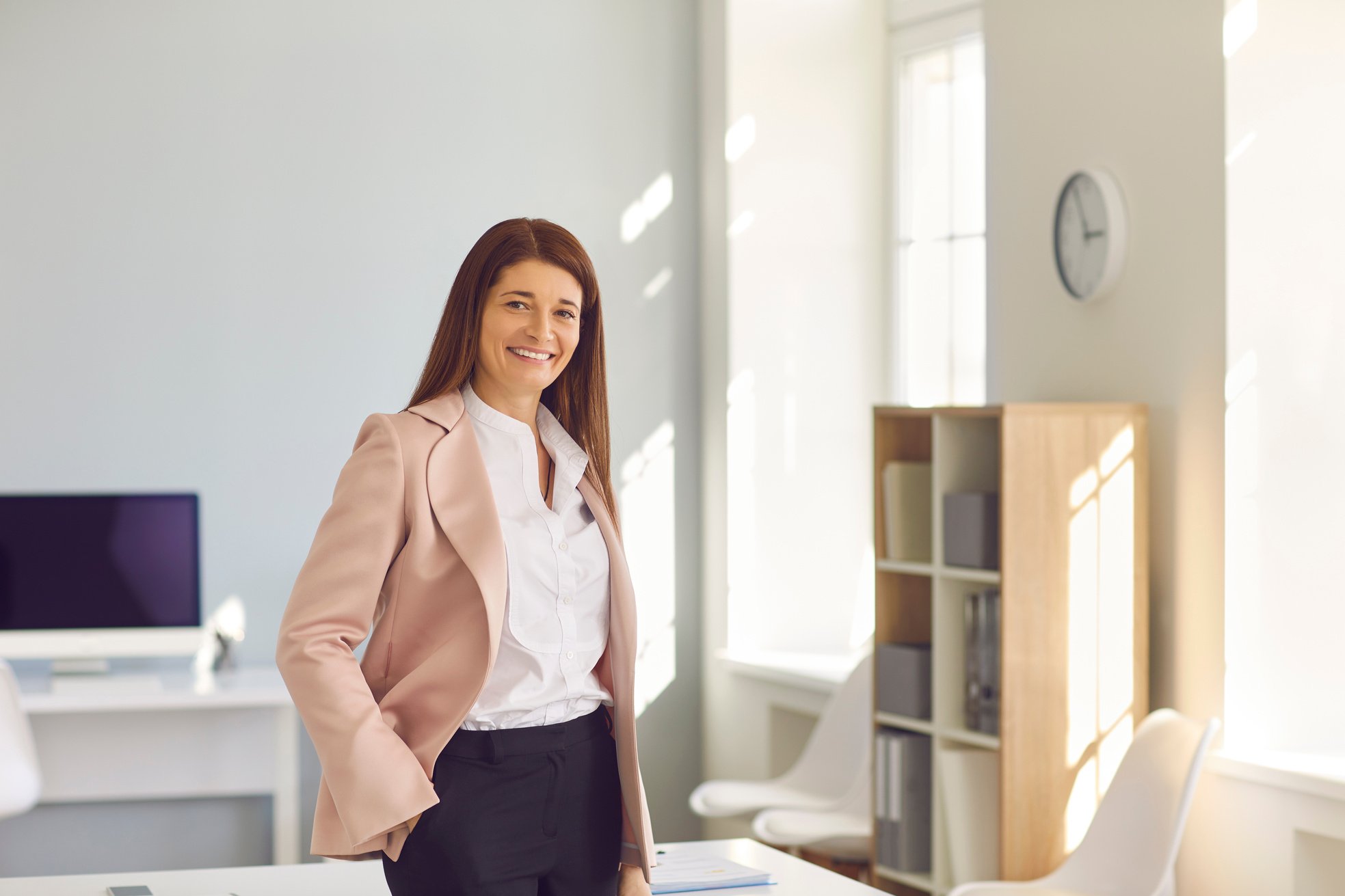 Portrait of a Smiling Stylish Business Woman Standing in the Office of a Modern Business Center.